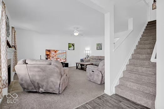 Carpeted living area with a ceiling fan light fixture