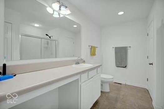 Bathroom featuring a single vanity with an integrated sink, wall-mounted mirror, and white cabinetry