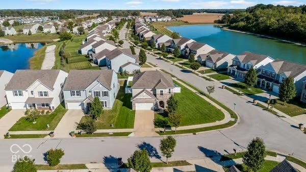 Residential neighborhood with single-family homes, paved streets, and a prominent lake feature