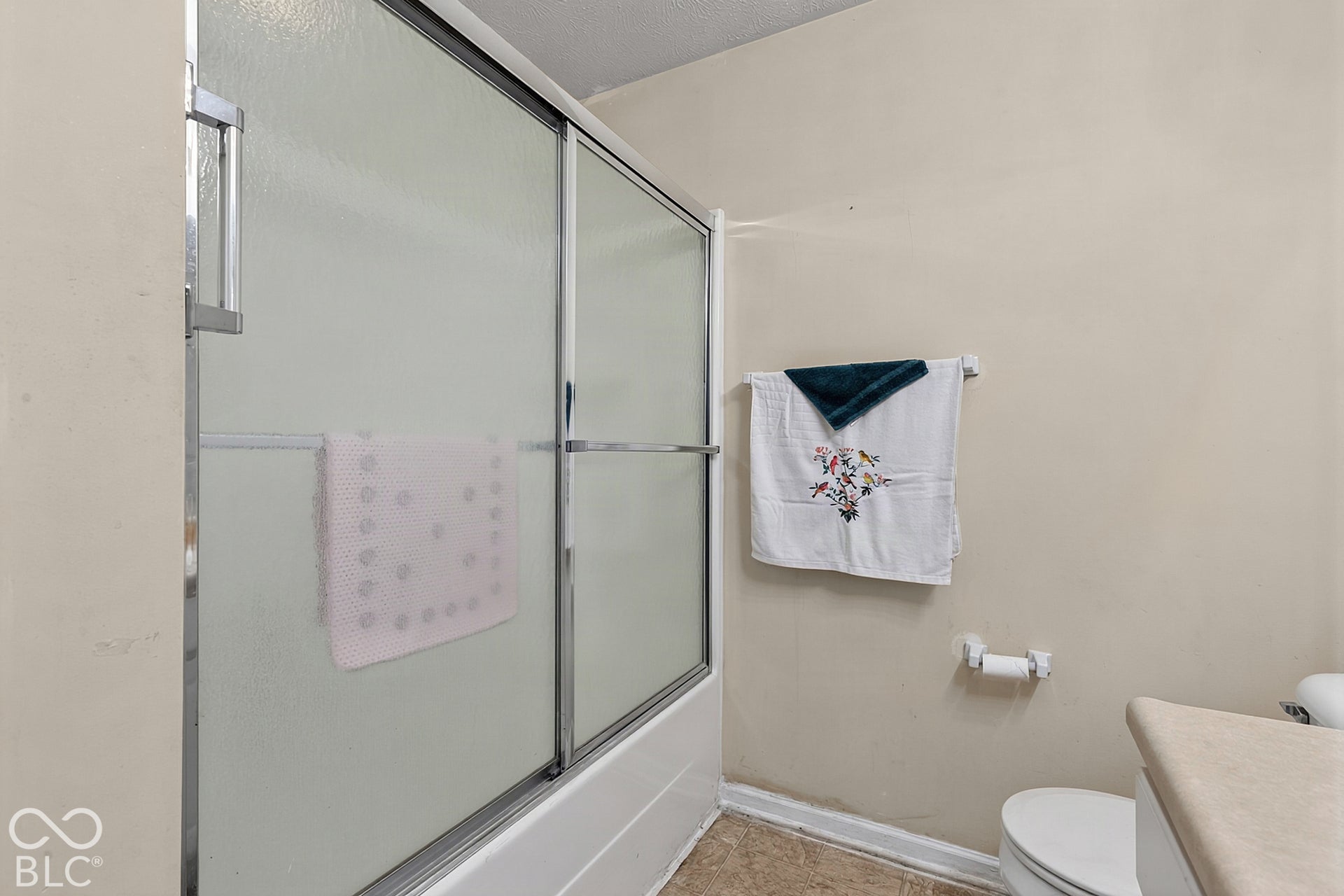 Bathtub with sliding glass enclosure and chrome hardware