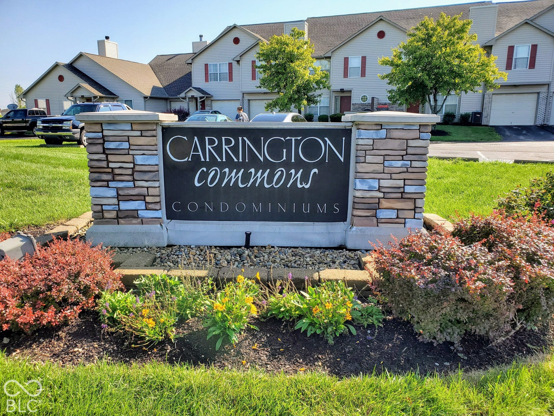 Stone-clad signage with established landscaping and a manicured lawn