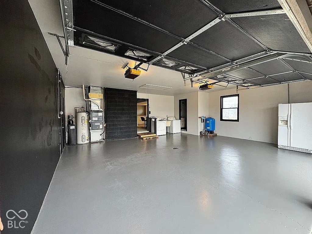 Spacious garage with light gray flooring and white walls