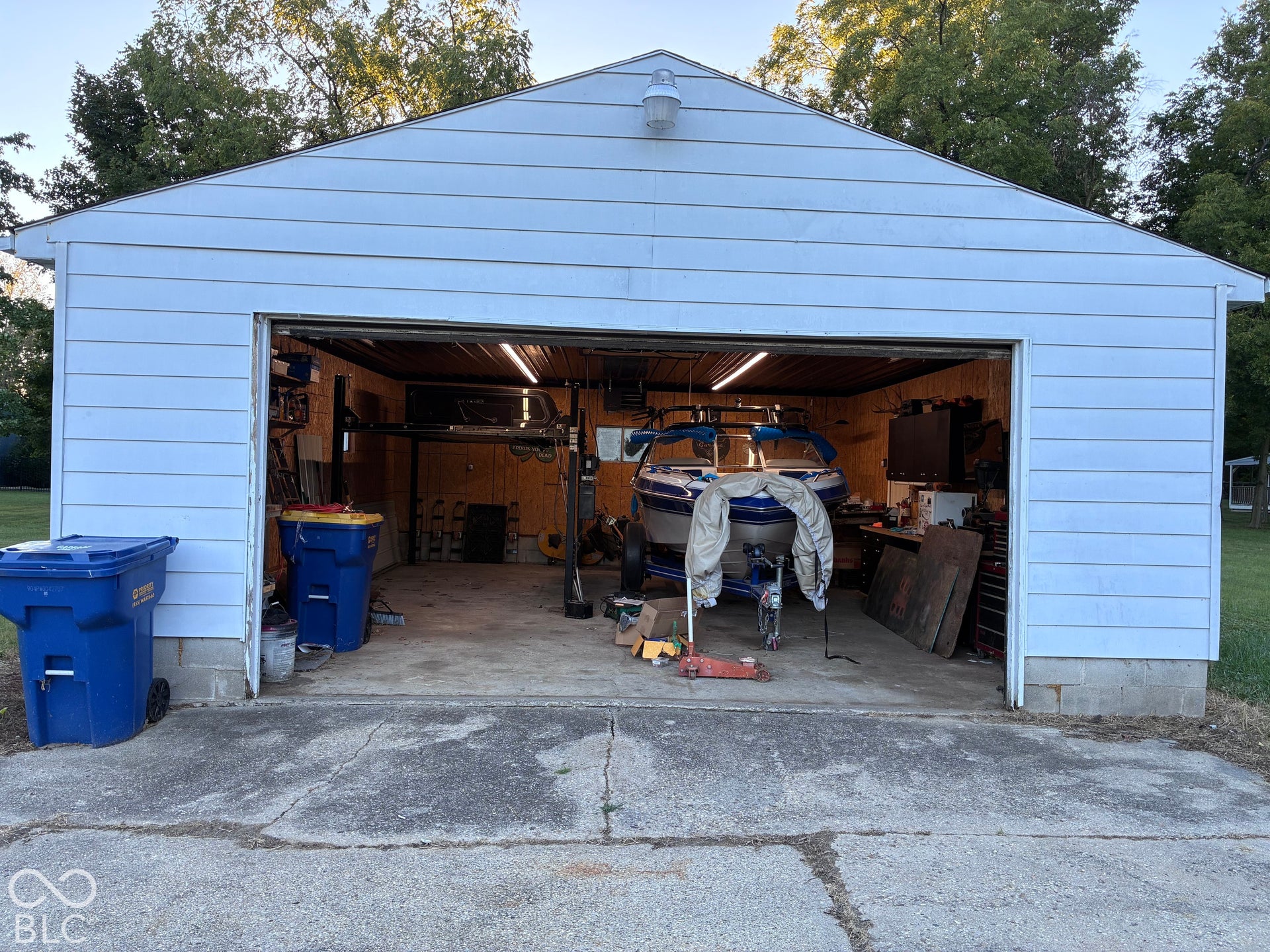 Detached garage featuring horizontal siding and an overhead garage door