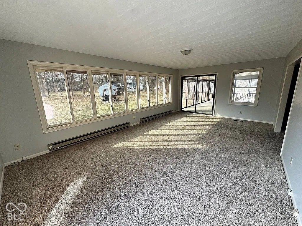 Spacious room featuring light gray walls and gray carpeting