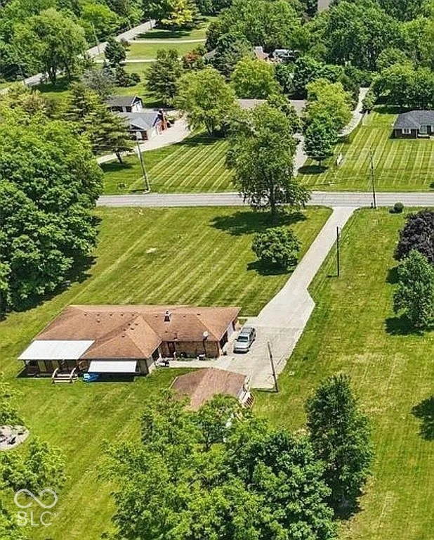 Expansive property with a long driveway, detached outbuilding, and mature trees