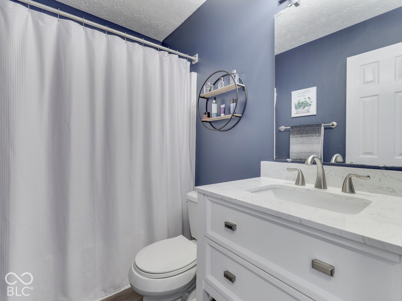 Refreshed upstairs hall bath with an updated vanity and new flooring.