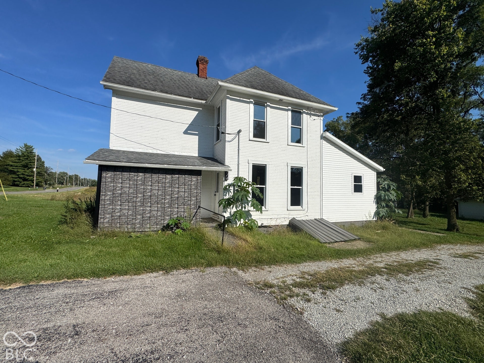 White painted siding exterior with a shingled roof