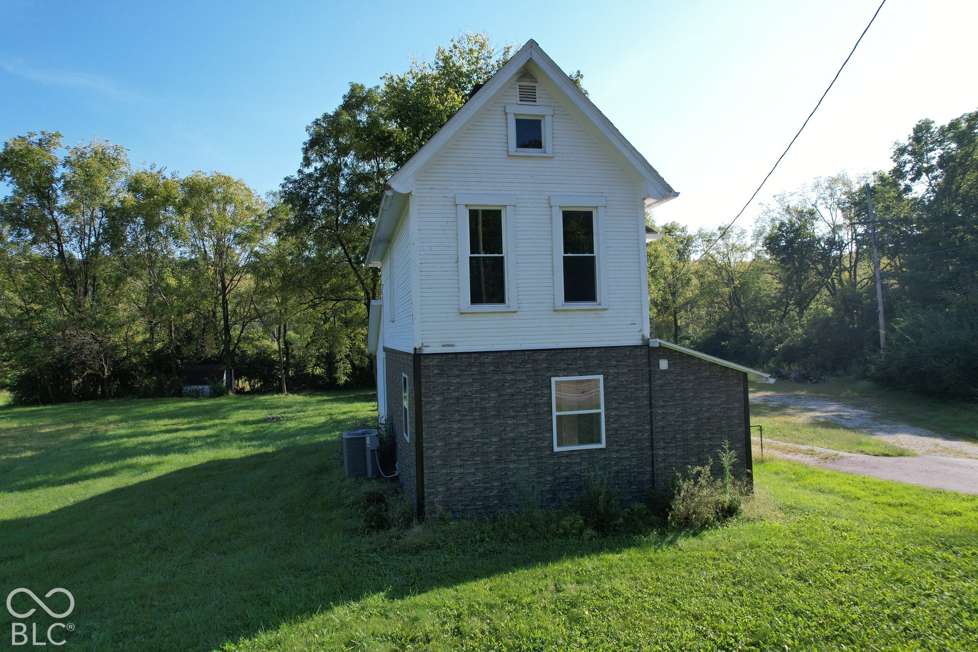 White exterior siding with dark stone-finish lower level