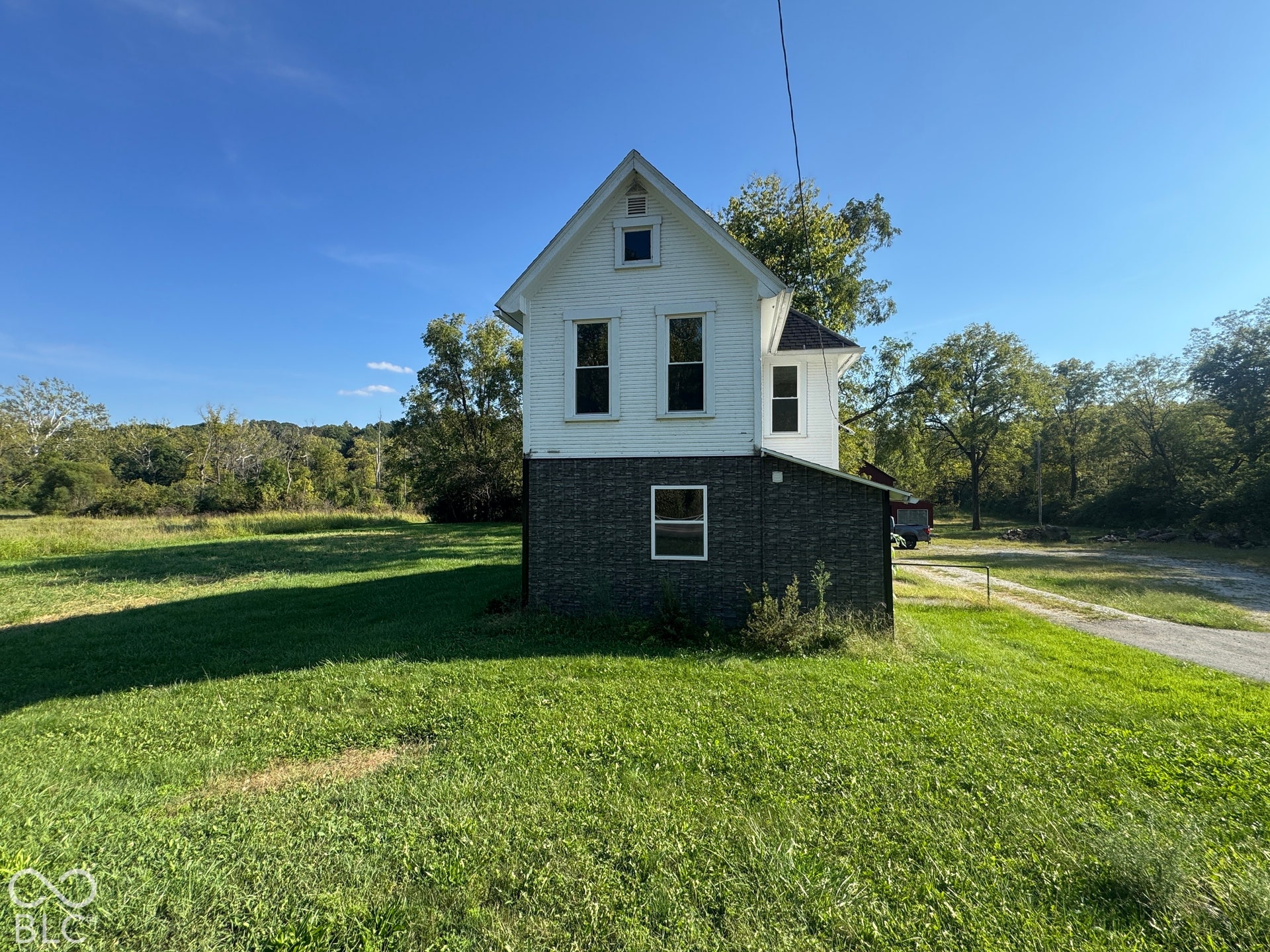 Two-story structure with white siding and a contrasting dark lower level