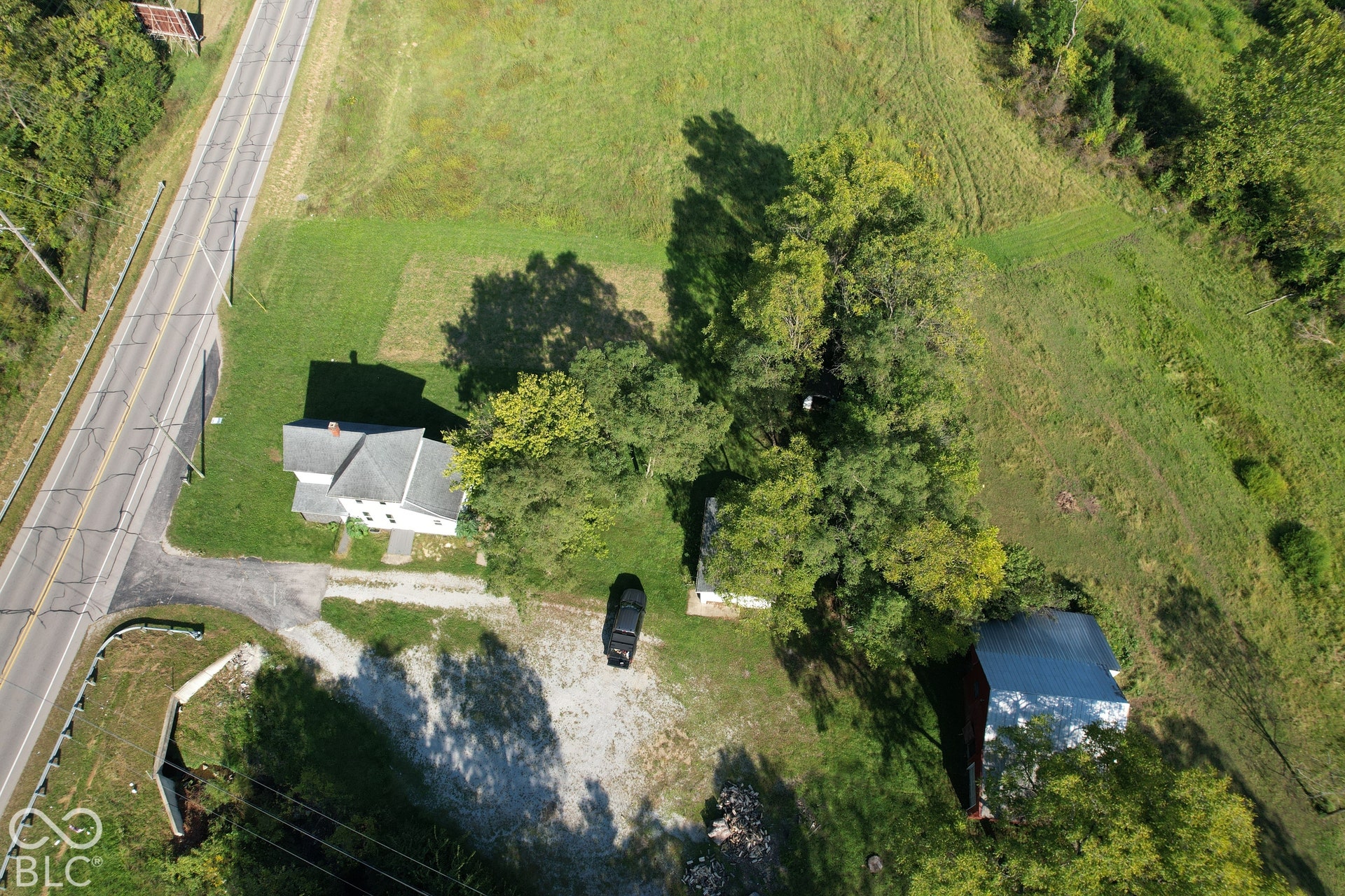 Expansive property featuring a detached residence, a secondary outbuilding, and mature trees