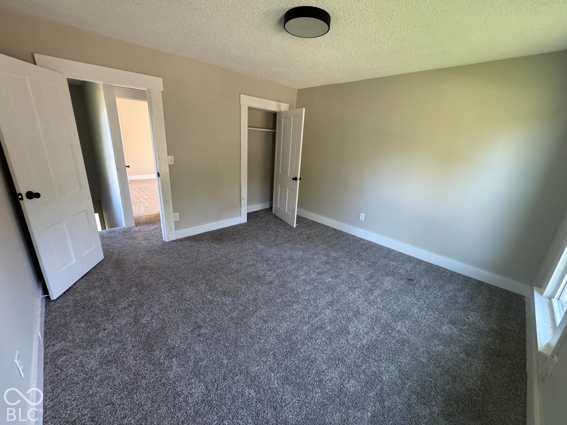 Neutral wall color, plush carpet, recessed lighting, white trim, and a built-in closet