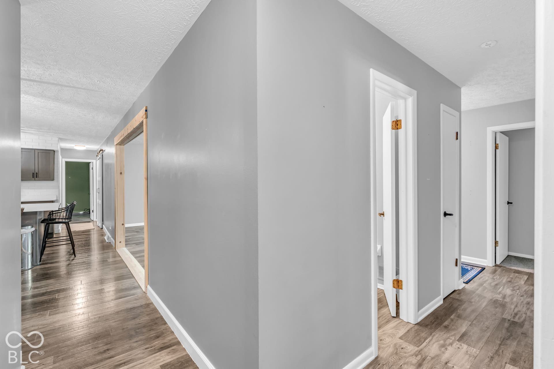 Wood-finish flooring throughout, light gray wall paint, and white trim accents