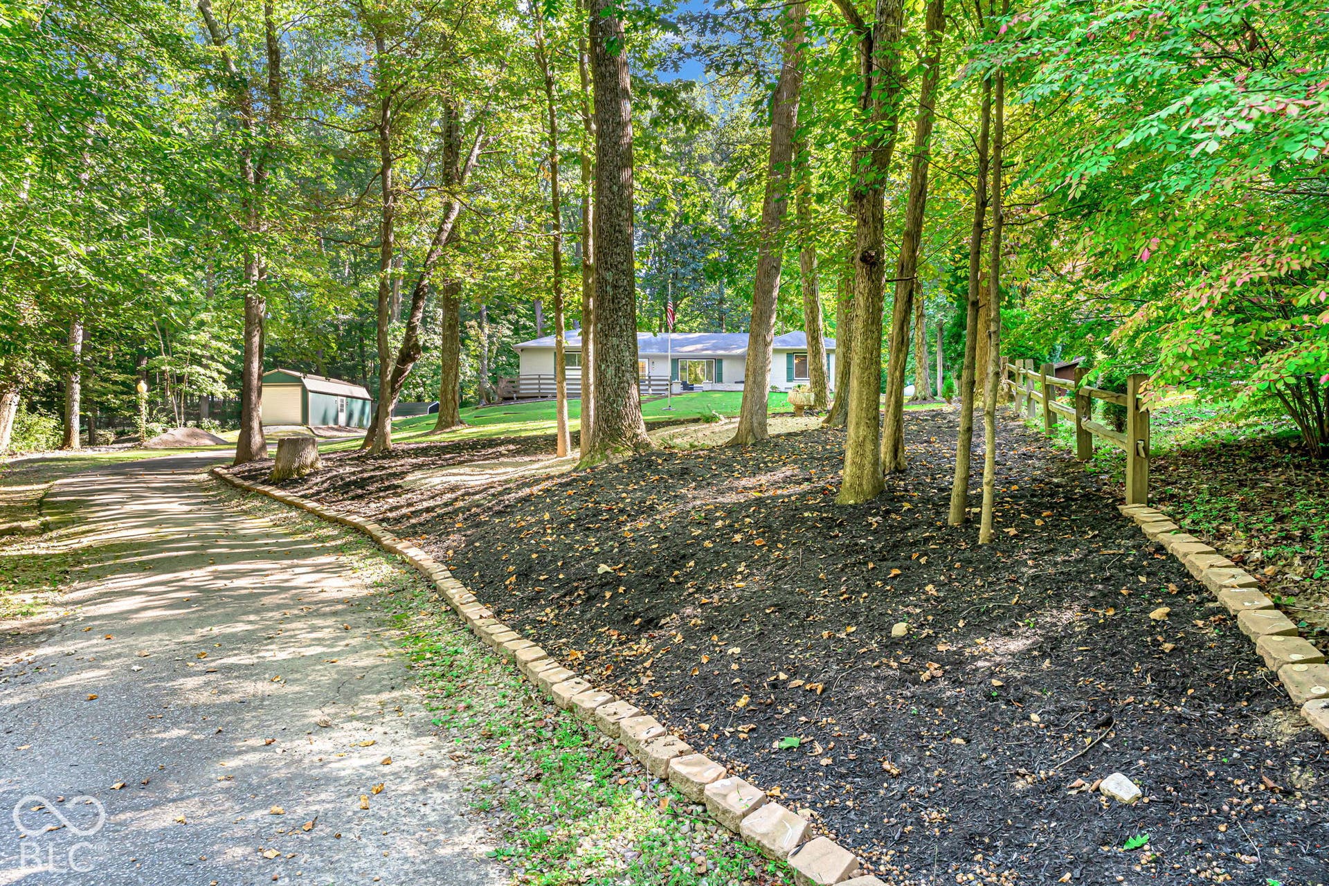Gravel driveway leading to the property, bordered by a stone landscape edging