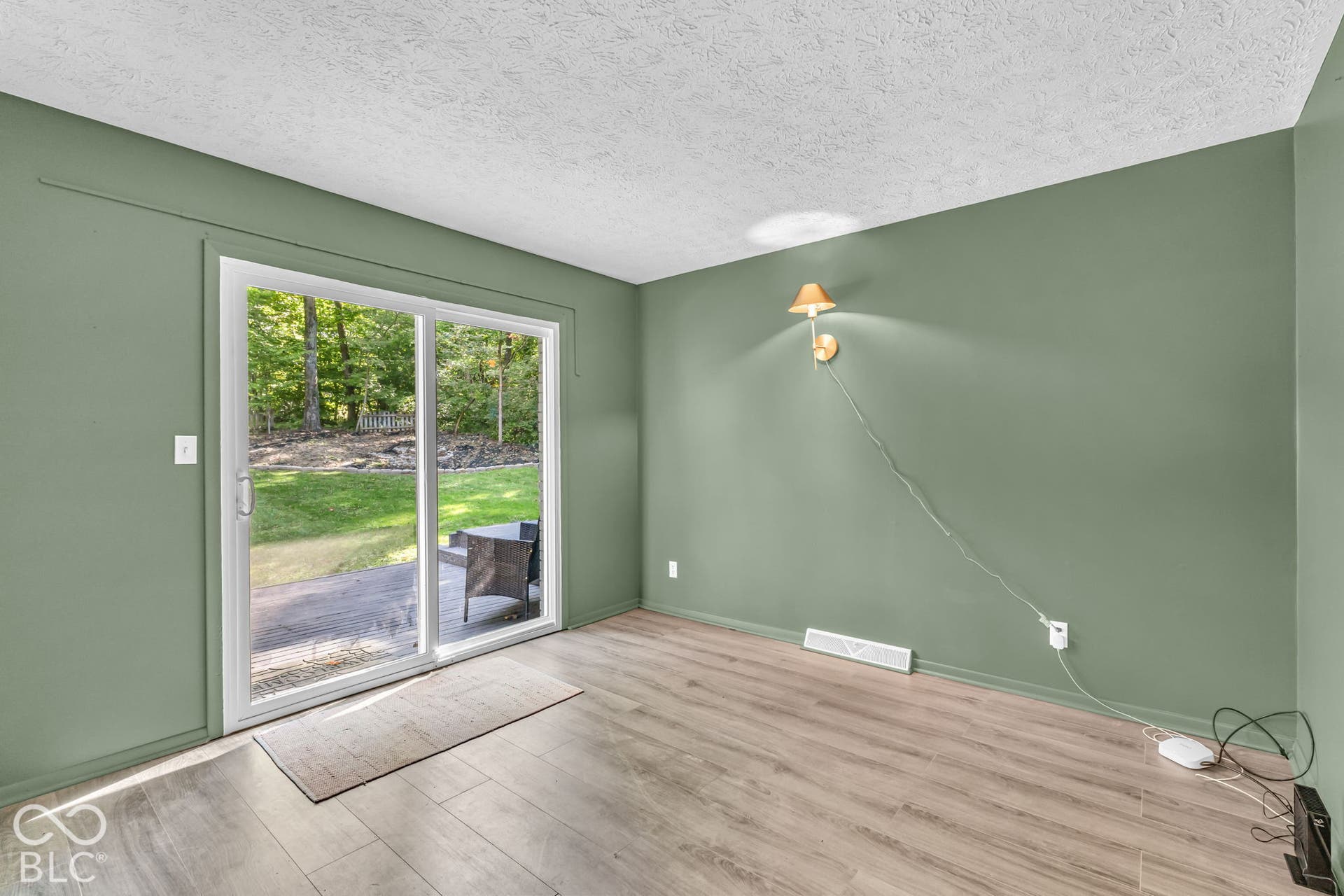 Sliding glass door leading to an outdoor patio with wood-finish flooring throughout