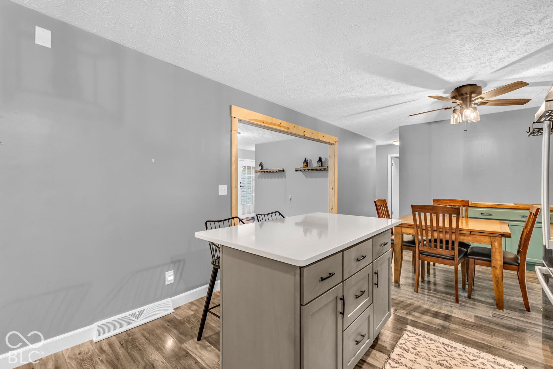 Kitchen island with white countertop and gray cabinetry