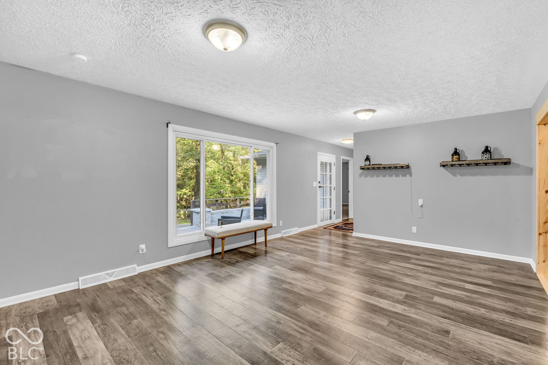 Wood-finish flooring throughout, recessed lighting, and a large sliding glass door
