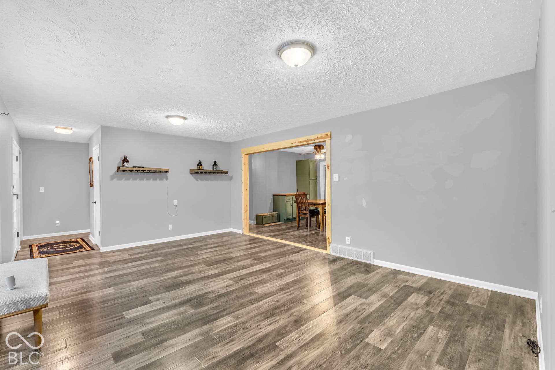 Wood-finish flooring throughout, light gray wall finishes, and recessed ceiling lighting