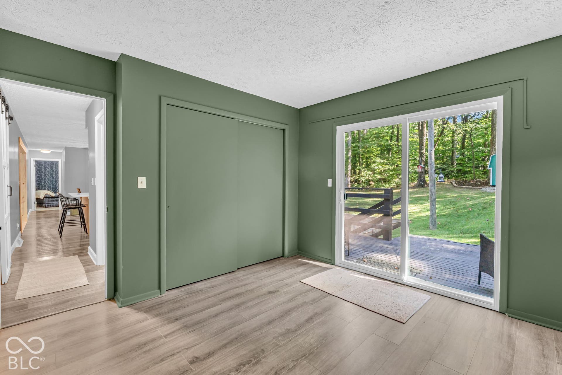 Wood-finish flooring, sliding glass doors, and a built-in closet with sliding doors