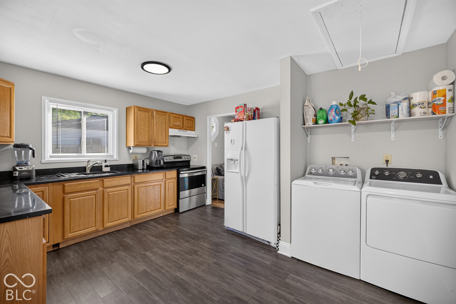 3241 Winton Avenue, Indianapolis, IN 46224 Wood-finish flooring, wood cabinetry, dark countertops, and stainless steel kitchen appliances