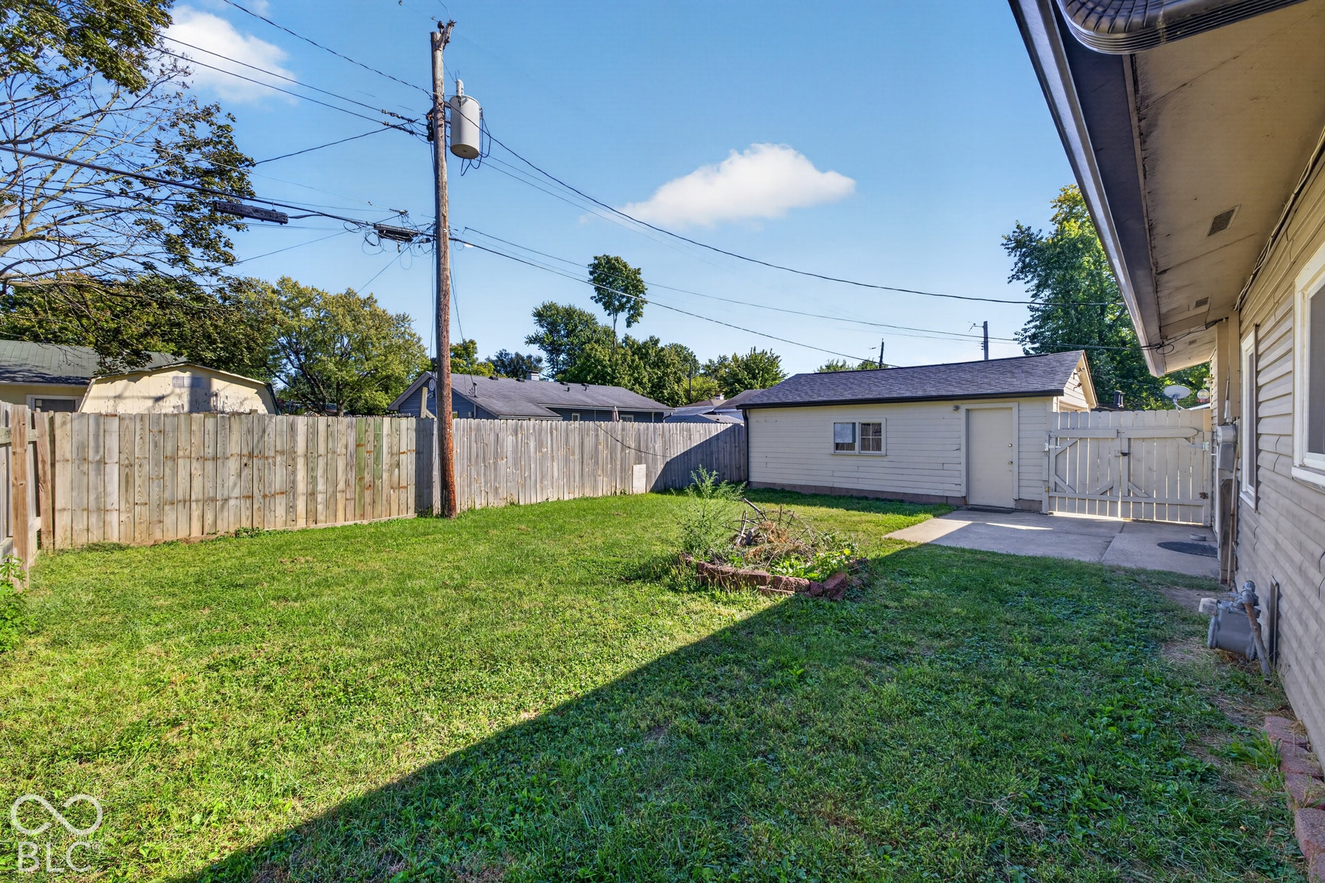 3241 Winton Avenue, Indianapolis, IN 46224 Expansive backyard featuring a privacy fence, concrete patio, and detached garage