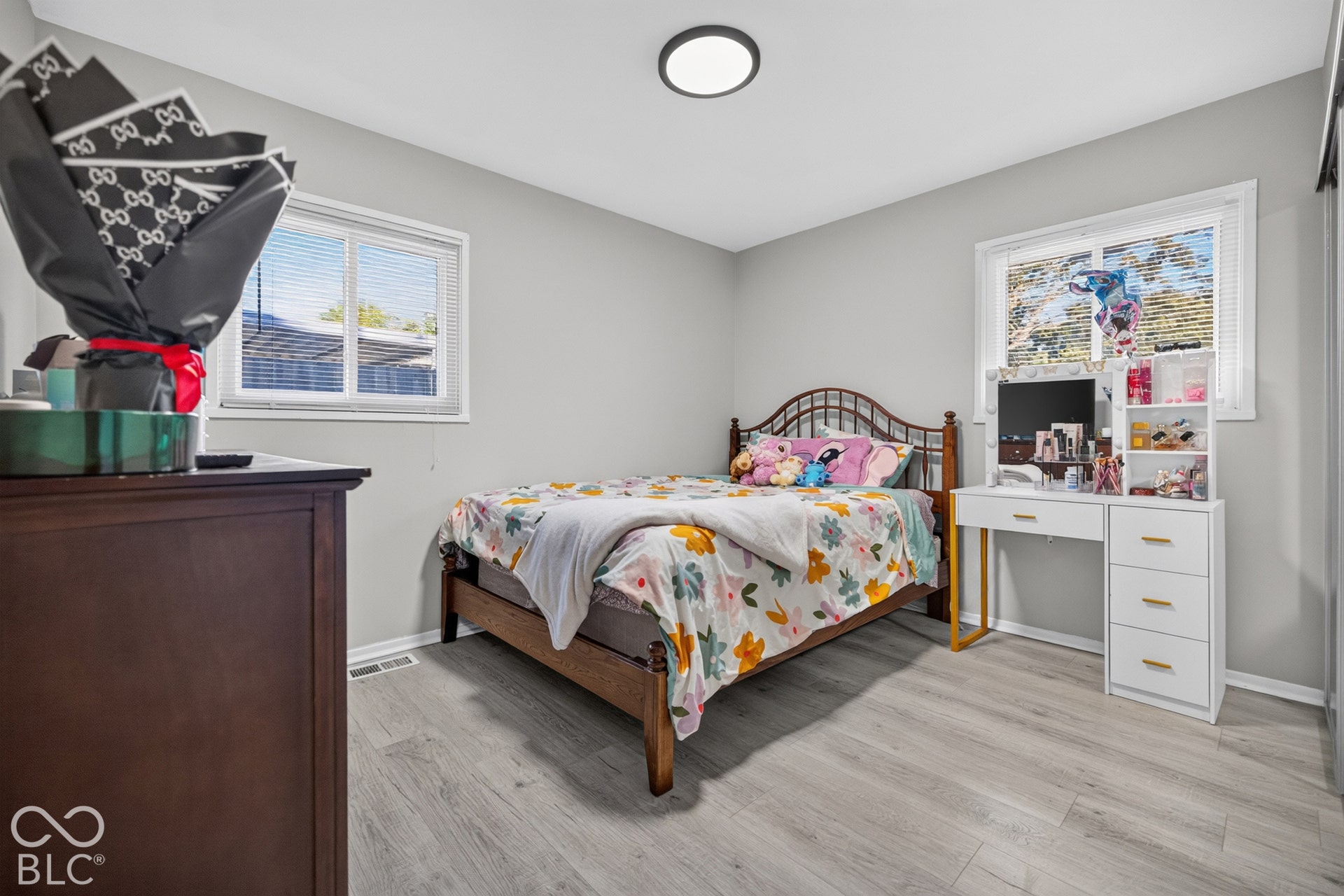 3241 Winton Avenue, Indianapolis, IN 46224 Light gray wall paint, wood-finish flooring, two windows with blinds, and a flush-mount ceiling light