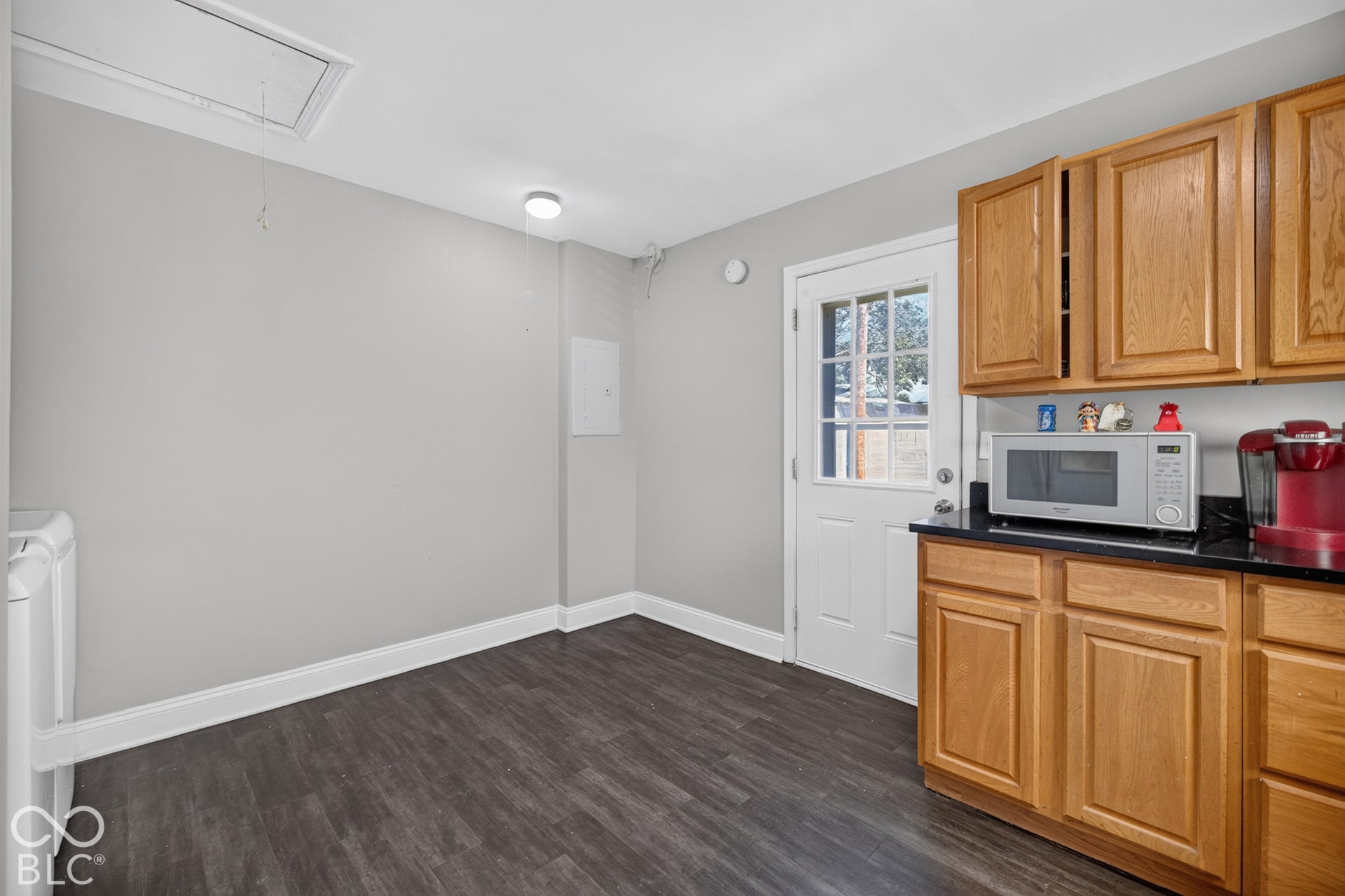 3241 Winton Avenue, Indianapolis, IN 46224 Wood-finish flooring, white trim, recessed lighting, wood cabinetry, and black countertops