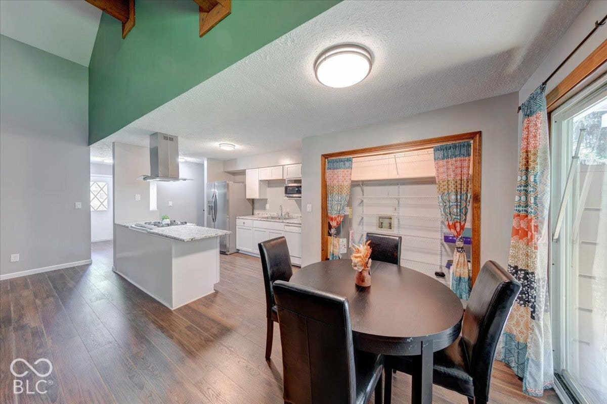 Open kitchen with white cabinetry and a central island with a gas stove cooktop.