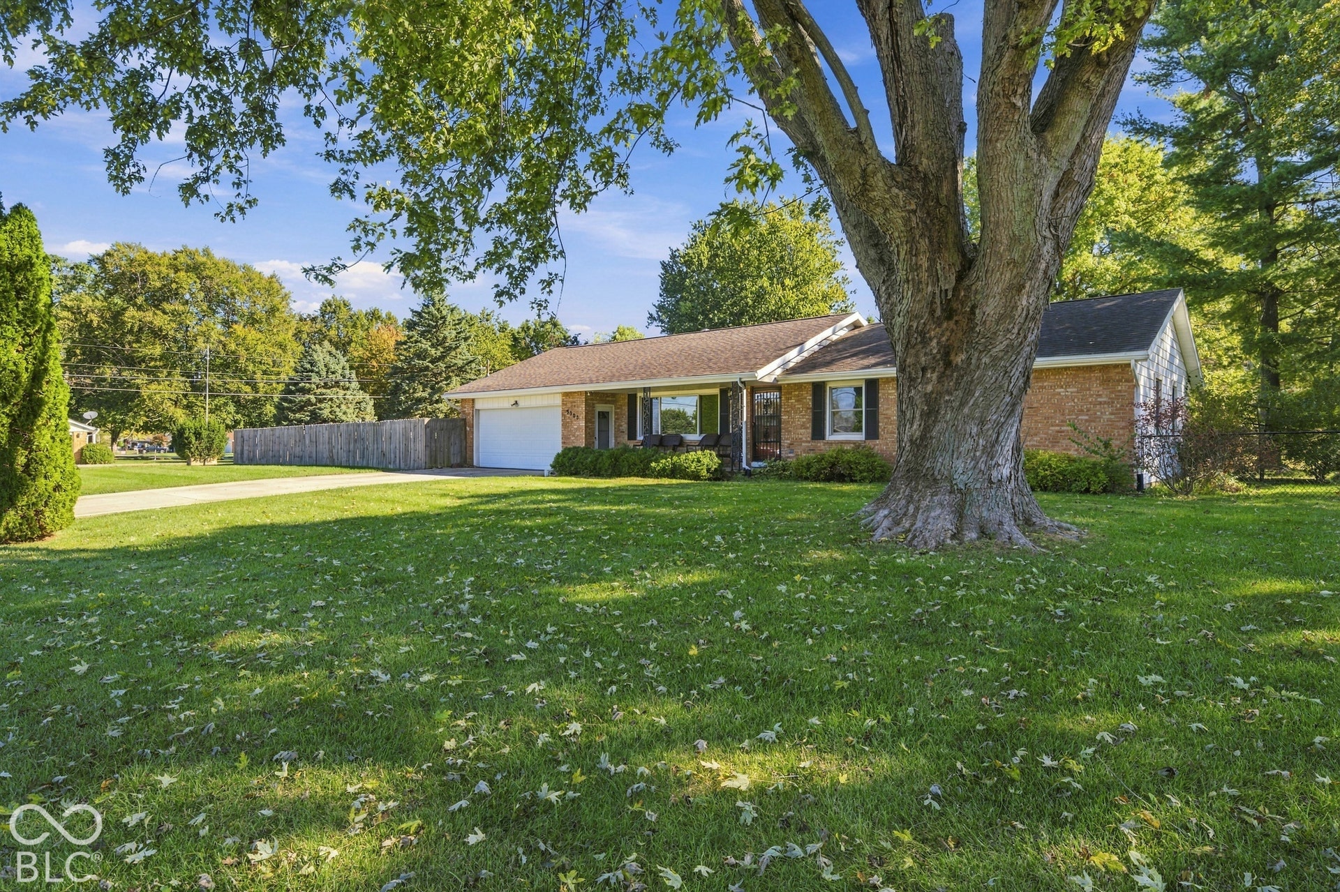 Brick exterior with white trim, attached two-car garage, and a paved driveway
