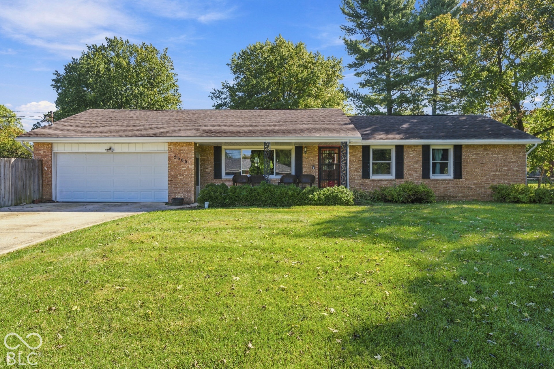 Brick exterior with white garage door and black shutters