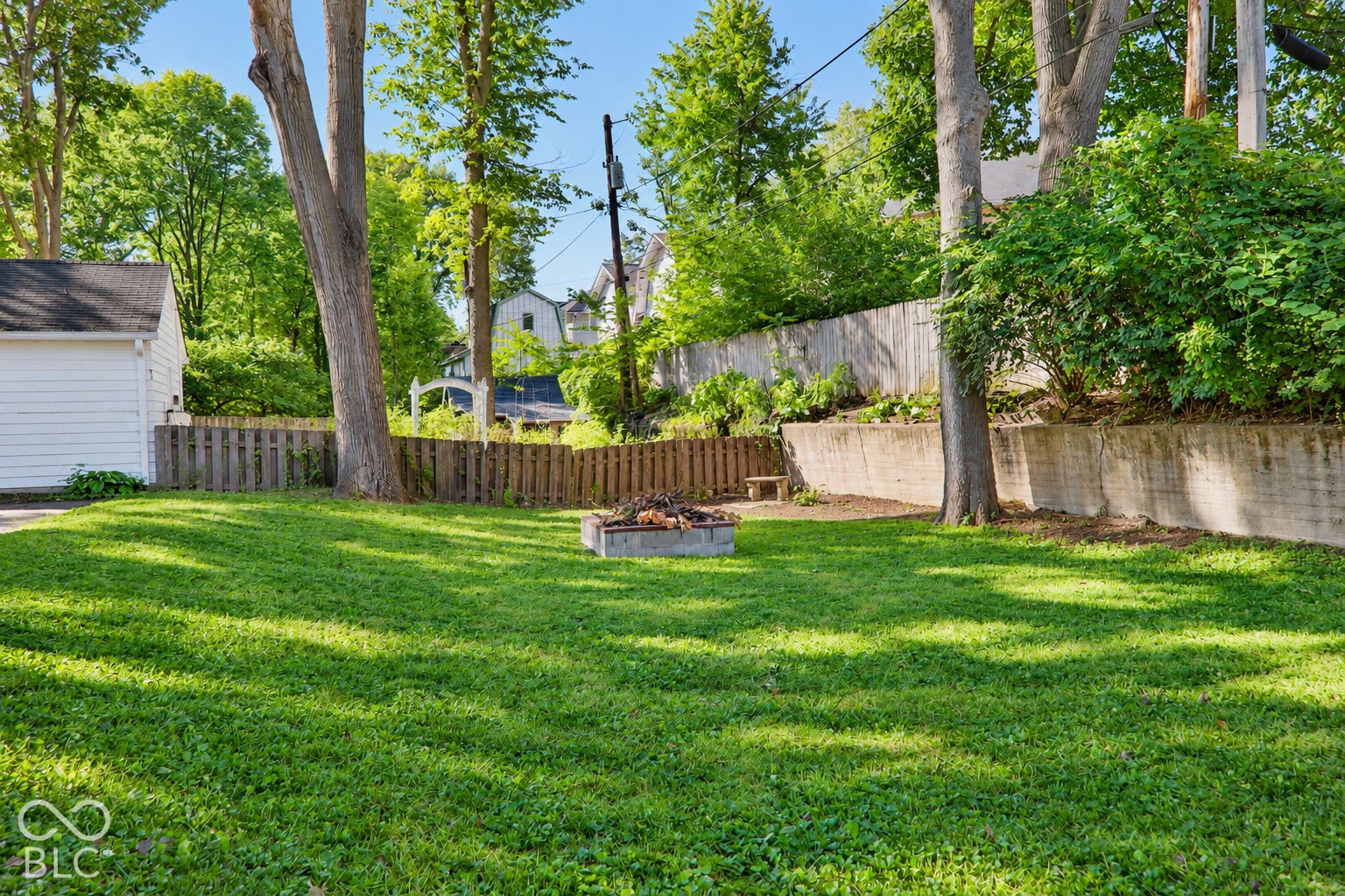 3566 Watson Road, Indianapolis, IN 46205 Expansive rear yard featuring a manicured lawn, established trees, and a wood privacy fence