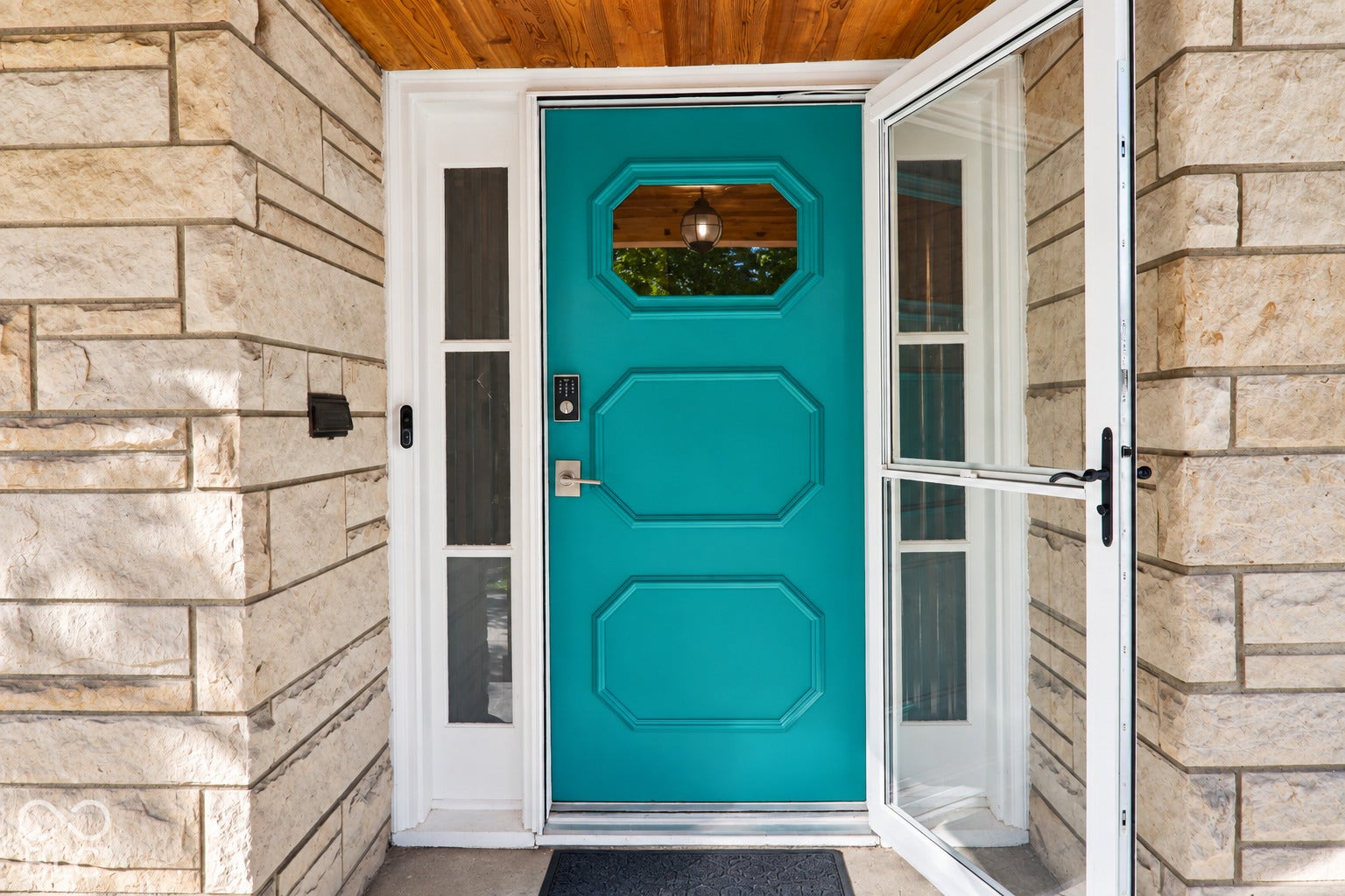3566 Watson Road, Indianapolis, IN 46205 Stone veneer exterior with a teal front door, white storm door, and wood-paneled ceiling