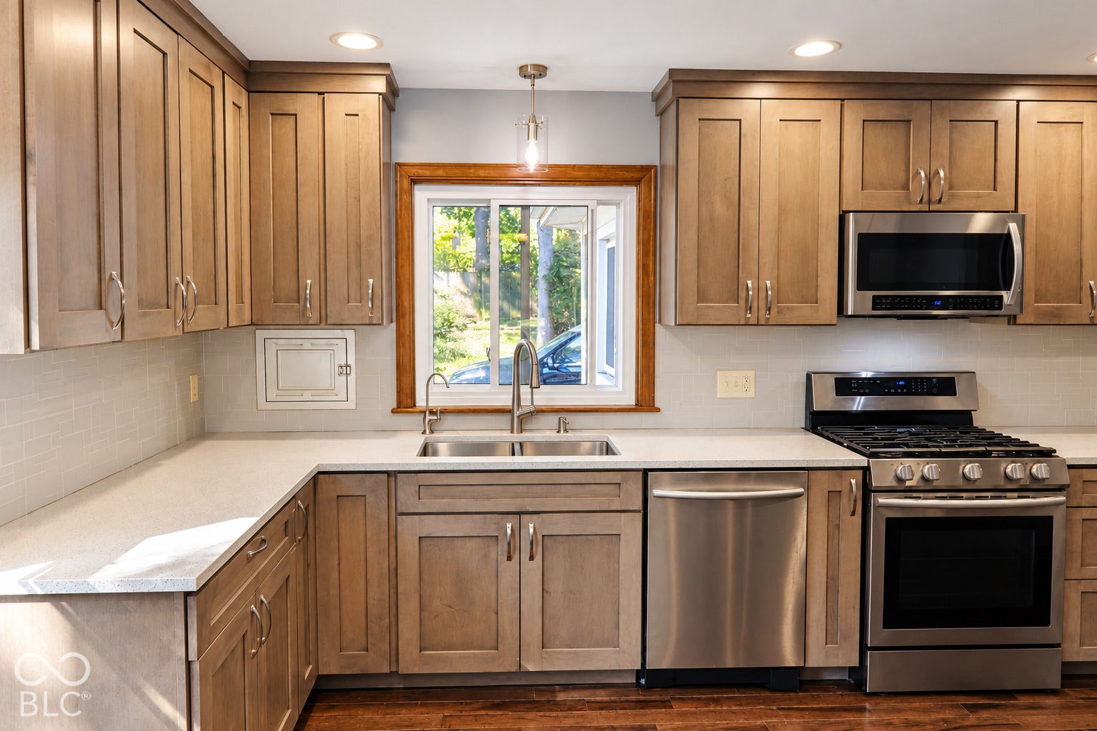3566 Watson Road, Indianapolis, IN 46205 Kitchen featuring shaker-style cabinetry, stainless steel appliances, a double basin sink, light-toned countertops, and horizontal tile backsplash