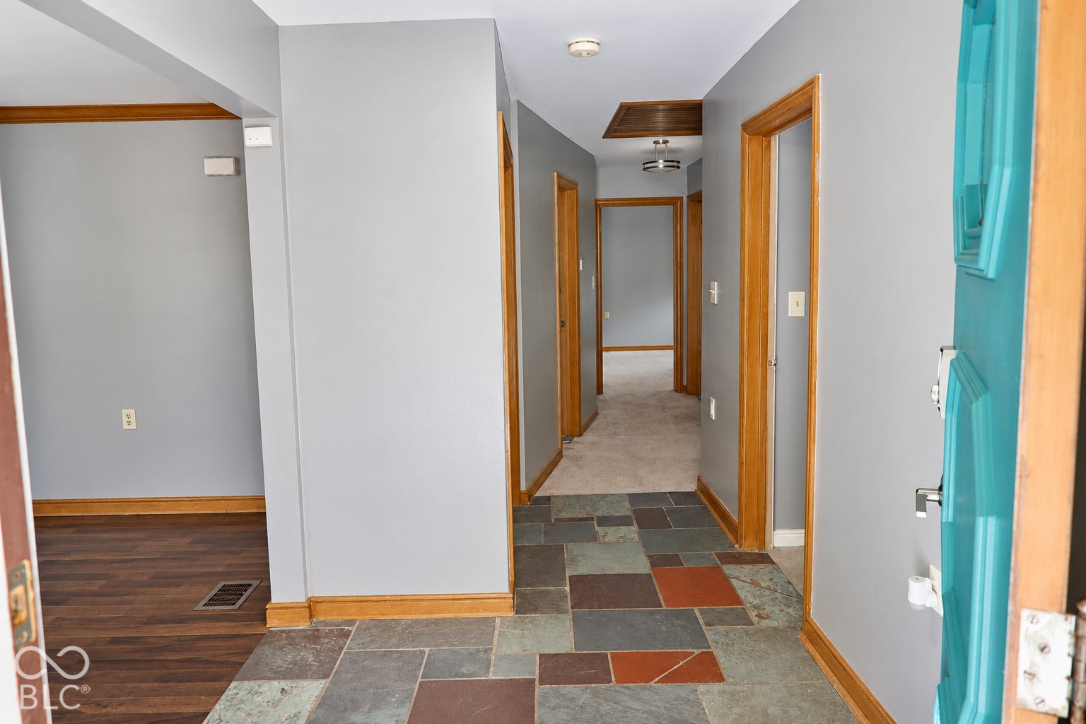 3566 Watson Road, Indianapolis, IN 46205 Slate tile flooring, wood-finish trim, interior wood-finish doors, recessed ceiling lighting, and a bright blue entry door