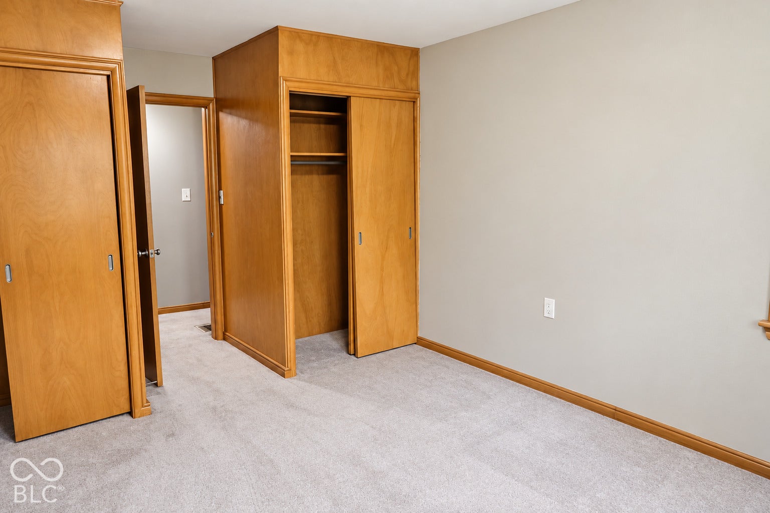 3566 Watson Road, Indianapolis, IN 46205 Light-toned wall paint, light-colored carpet flooring, wood-finish doors, and built-in closet with shelving