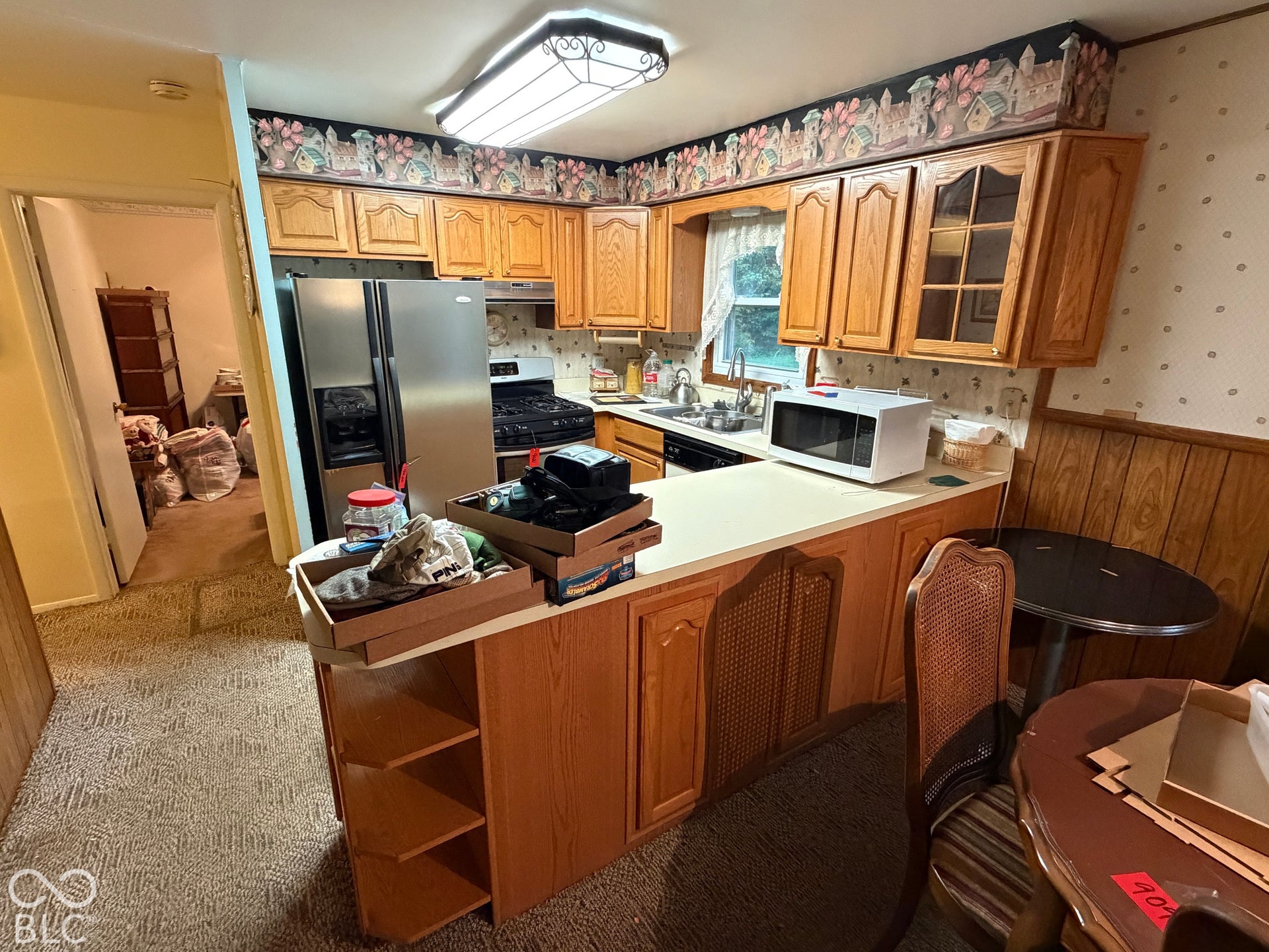 Kitchen featuring wood cabinetry, stainless steel refrigerator, and a built-in breakfast bar