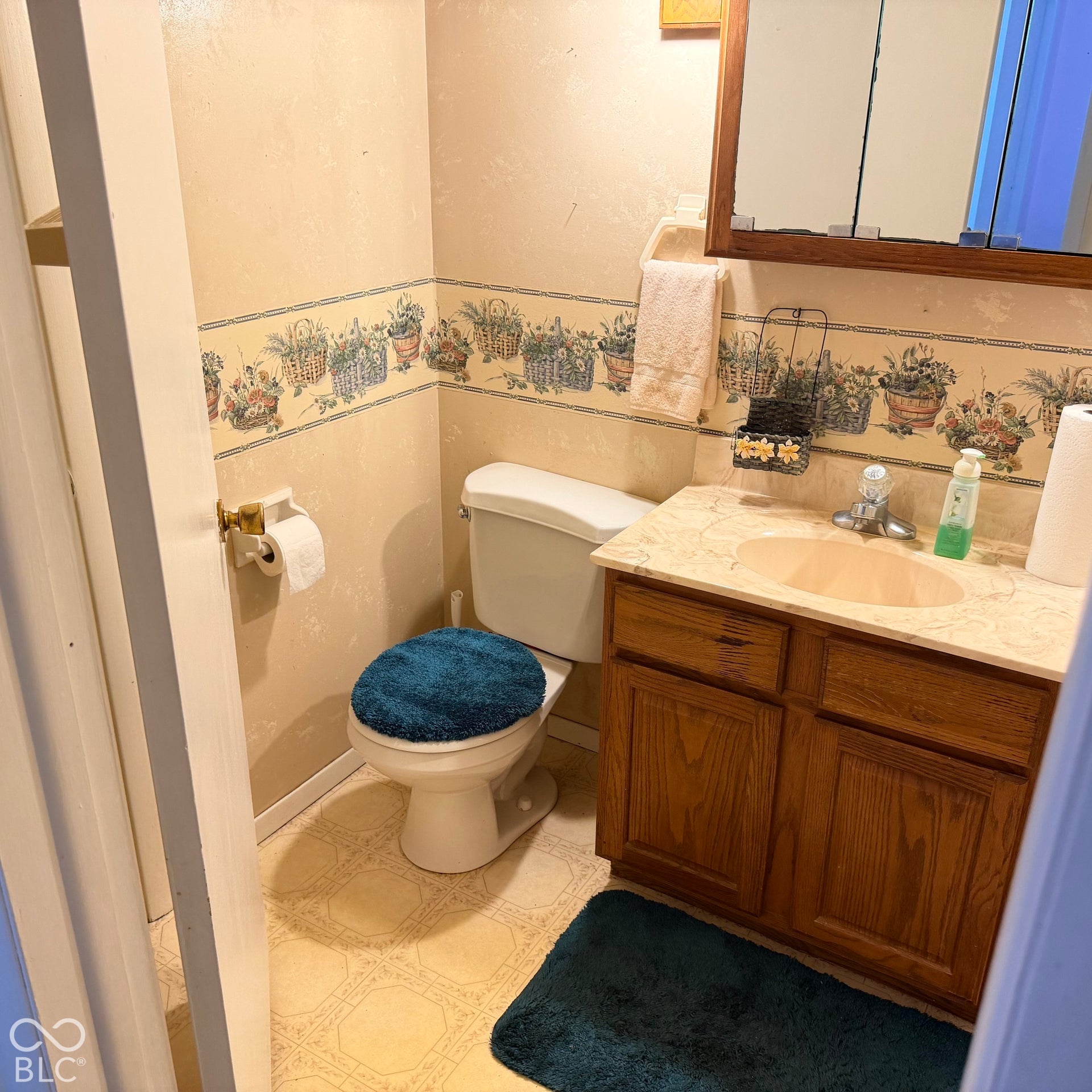 Vanity with an integrated sink and base cabinetry, complemented by a wall-mounted medicine cabinet and a toilet