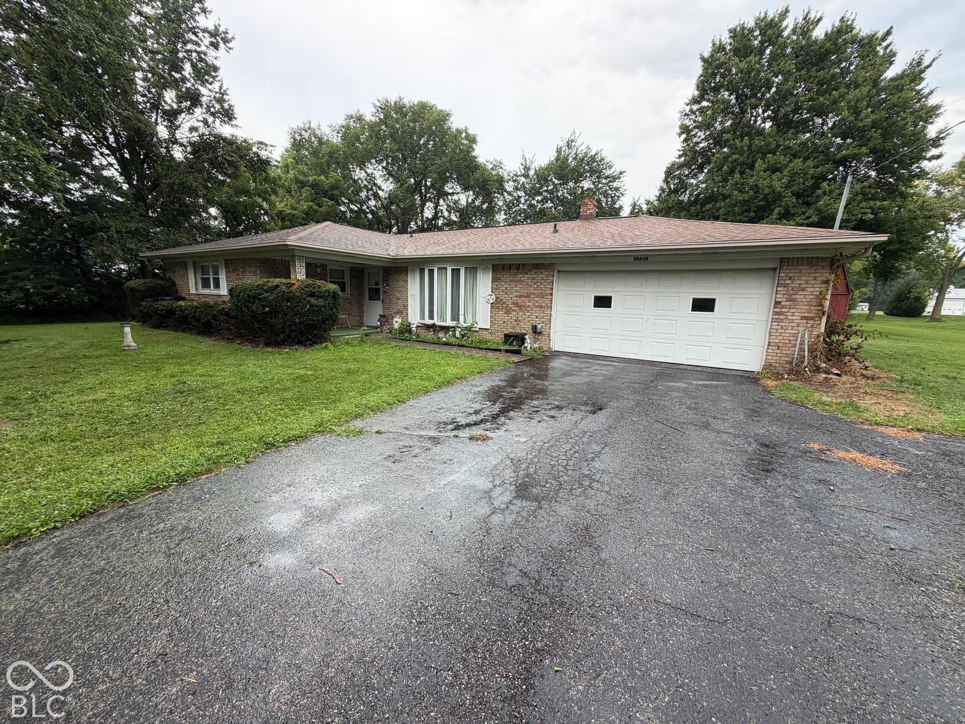 Brick exterior with a peaked roofline, front-facing two-car garage, and a bay window feature