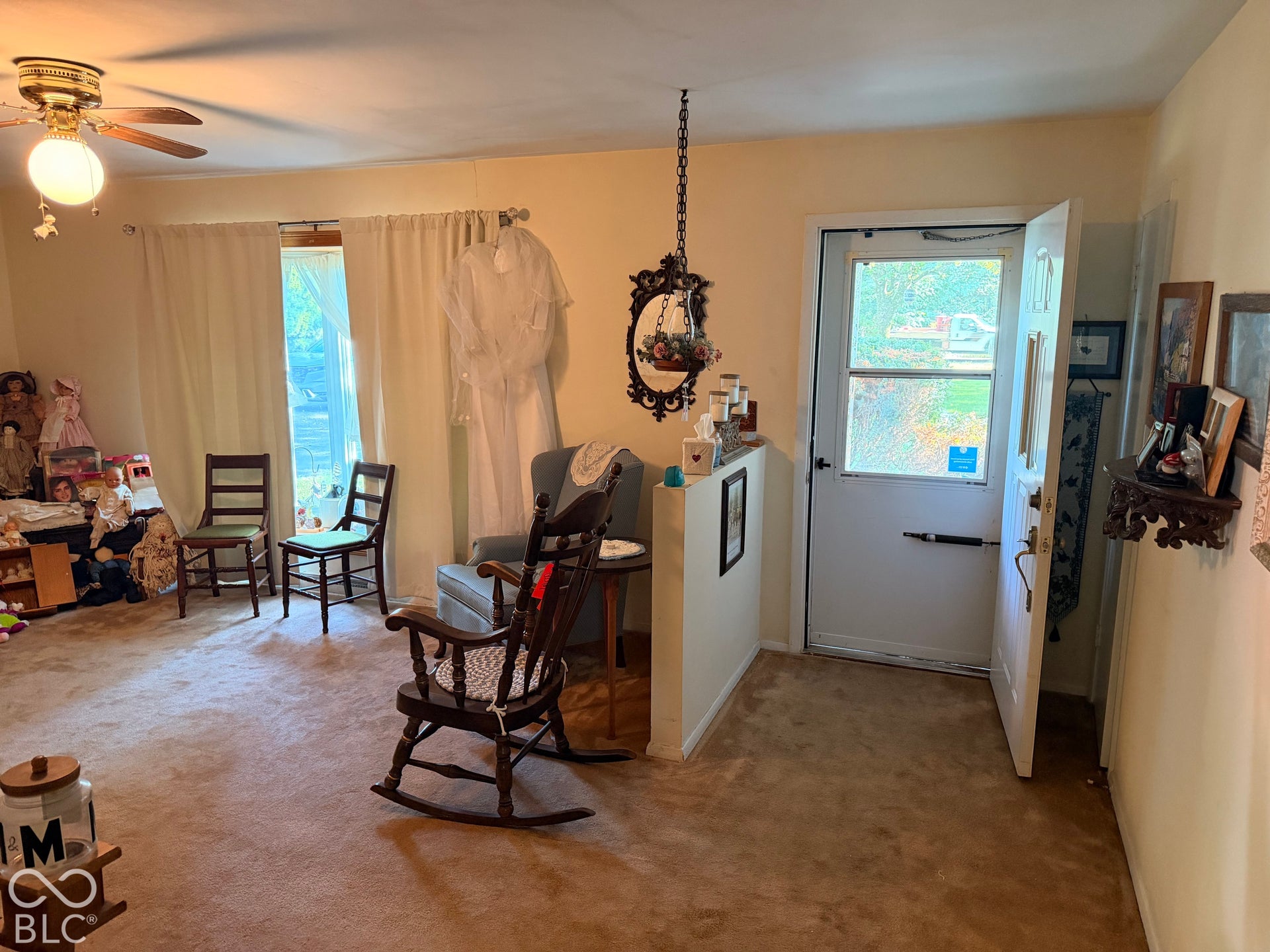 Entryway featuring a white door with a glass pane, warm-toned carpeting, and a ceiling fan with integrated lighting