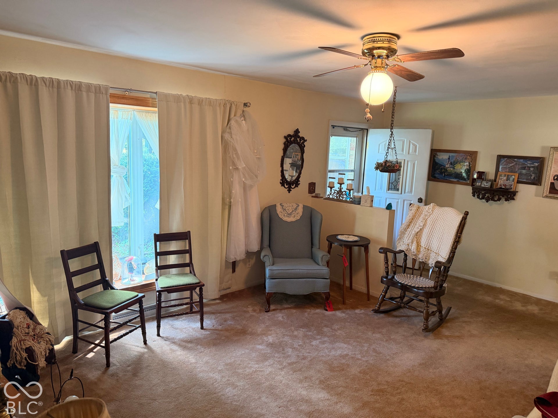 Carpet flooring, ceiling fan with integrated lighting, and a window with curtain rods