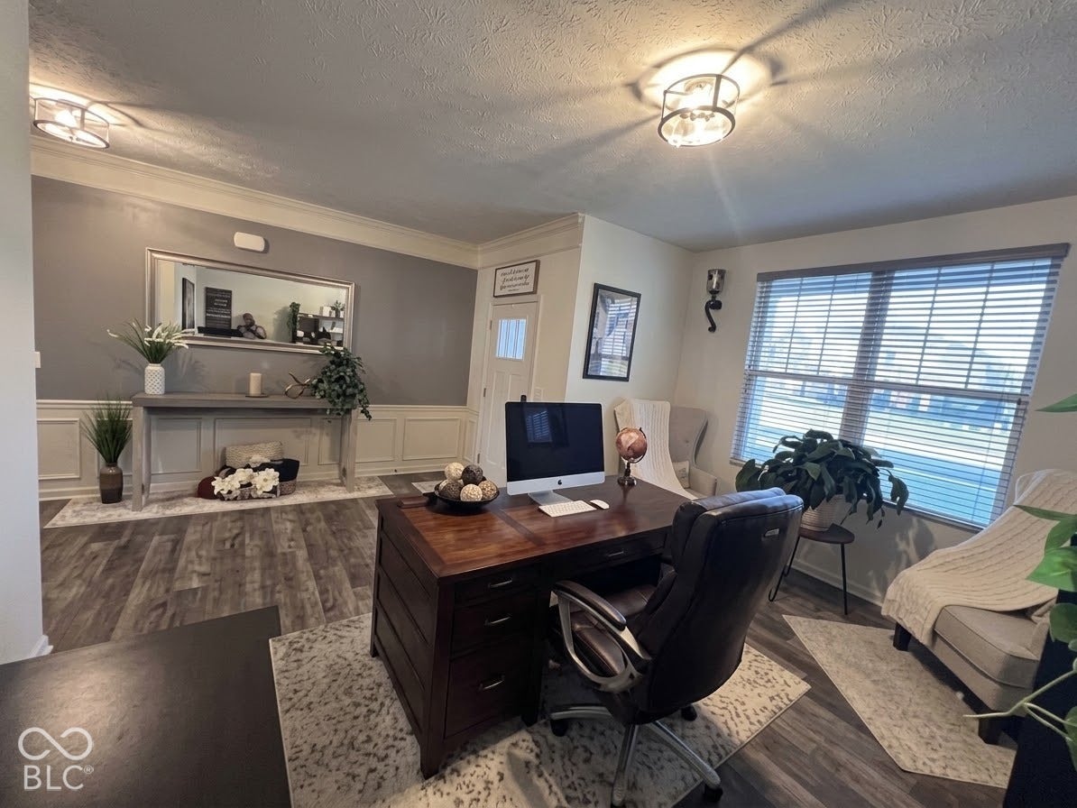Wood-finish flooring, wainscoting detail, recessed lighting, and a large window with blinds