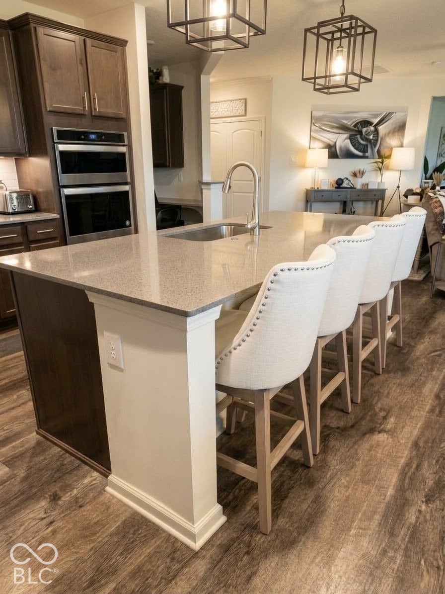 Kitchen island with an undermount sink, gooseneck faucet, and light-toned countertop