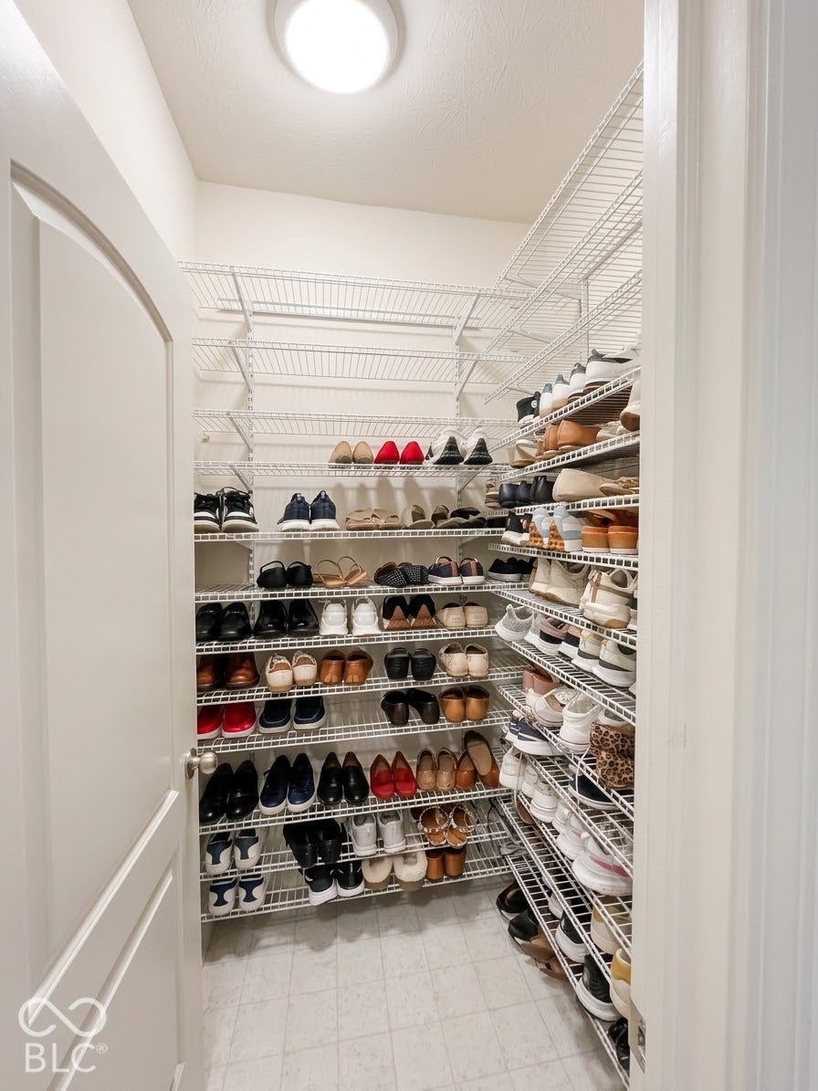 Walk-in closet with extensive wire shelving, overhead lighting, and tile flooring