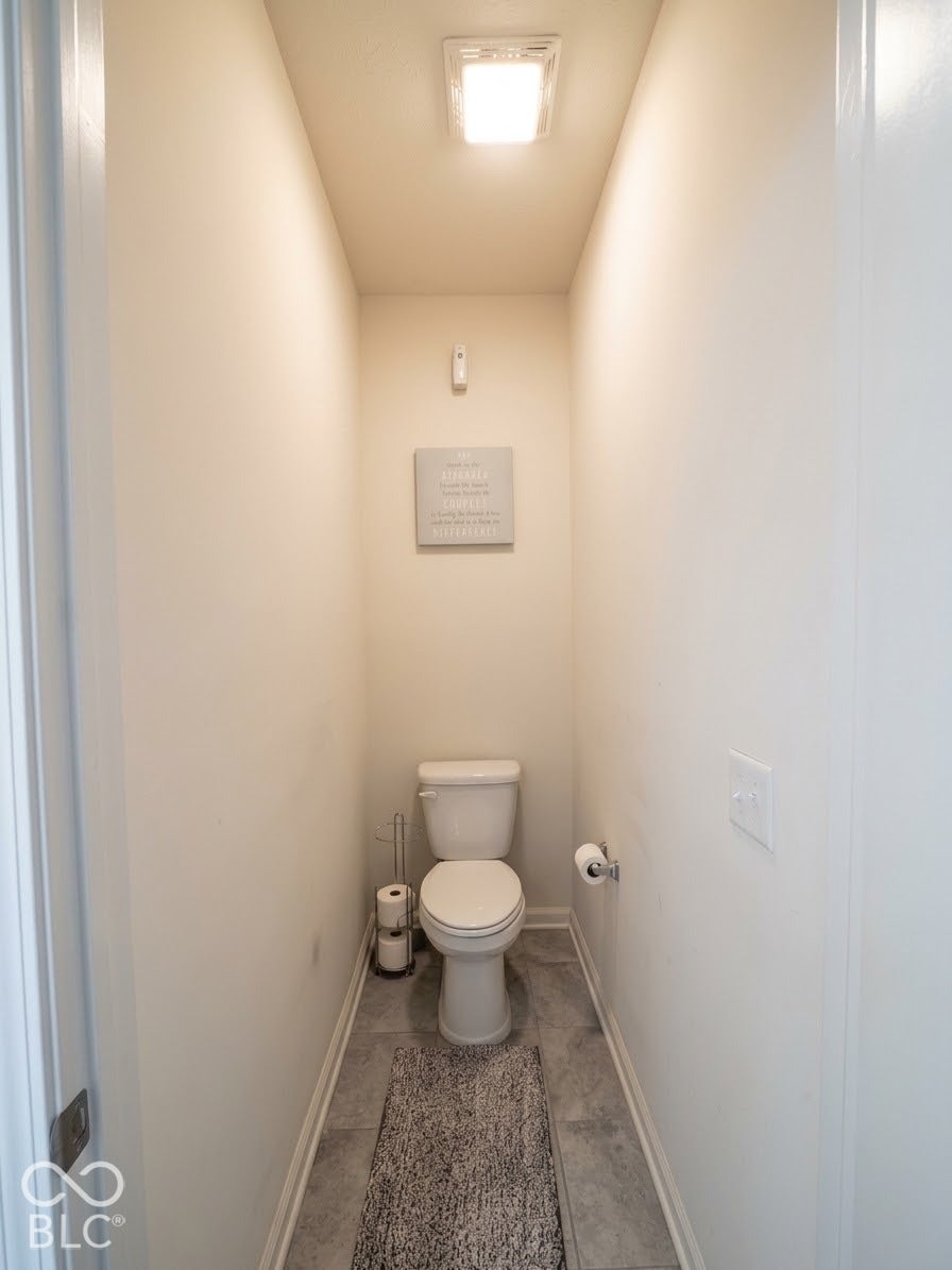 Recessed overhead lighting, light neutral wall paint, white trim, and a white toilet