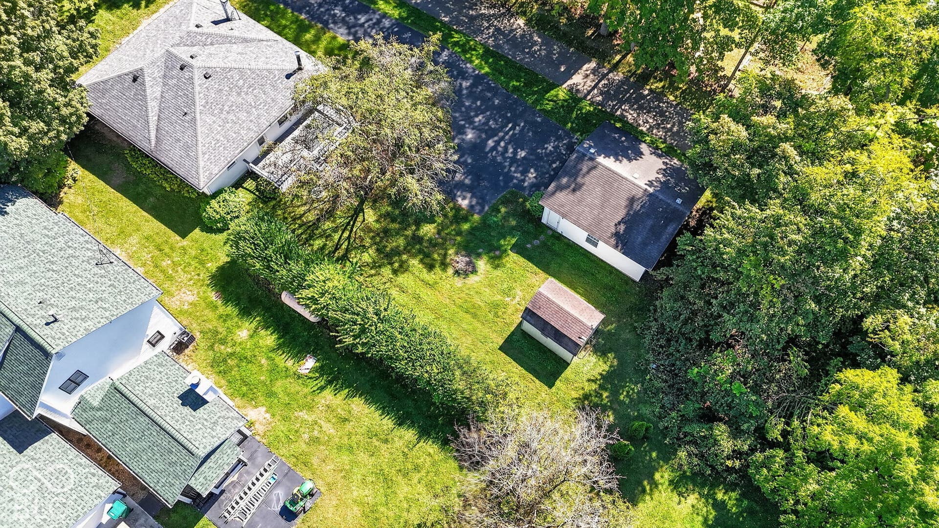 Expansive grounds featuring a detached storage shed and mature perimeter trees