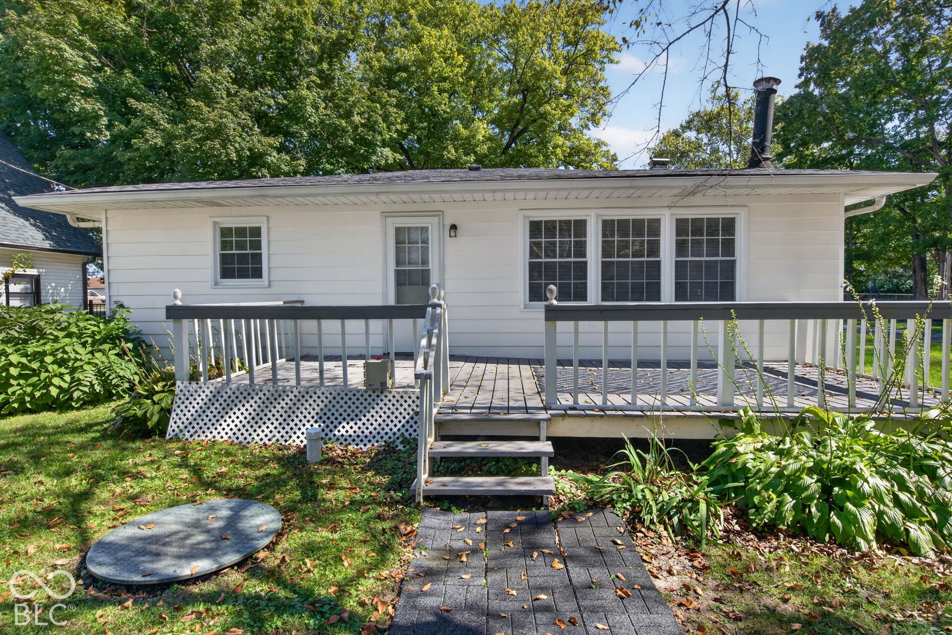 Rear exterior featuring white horizontal siding, a multi-pane glass door, and a multi-pane window