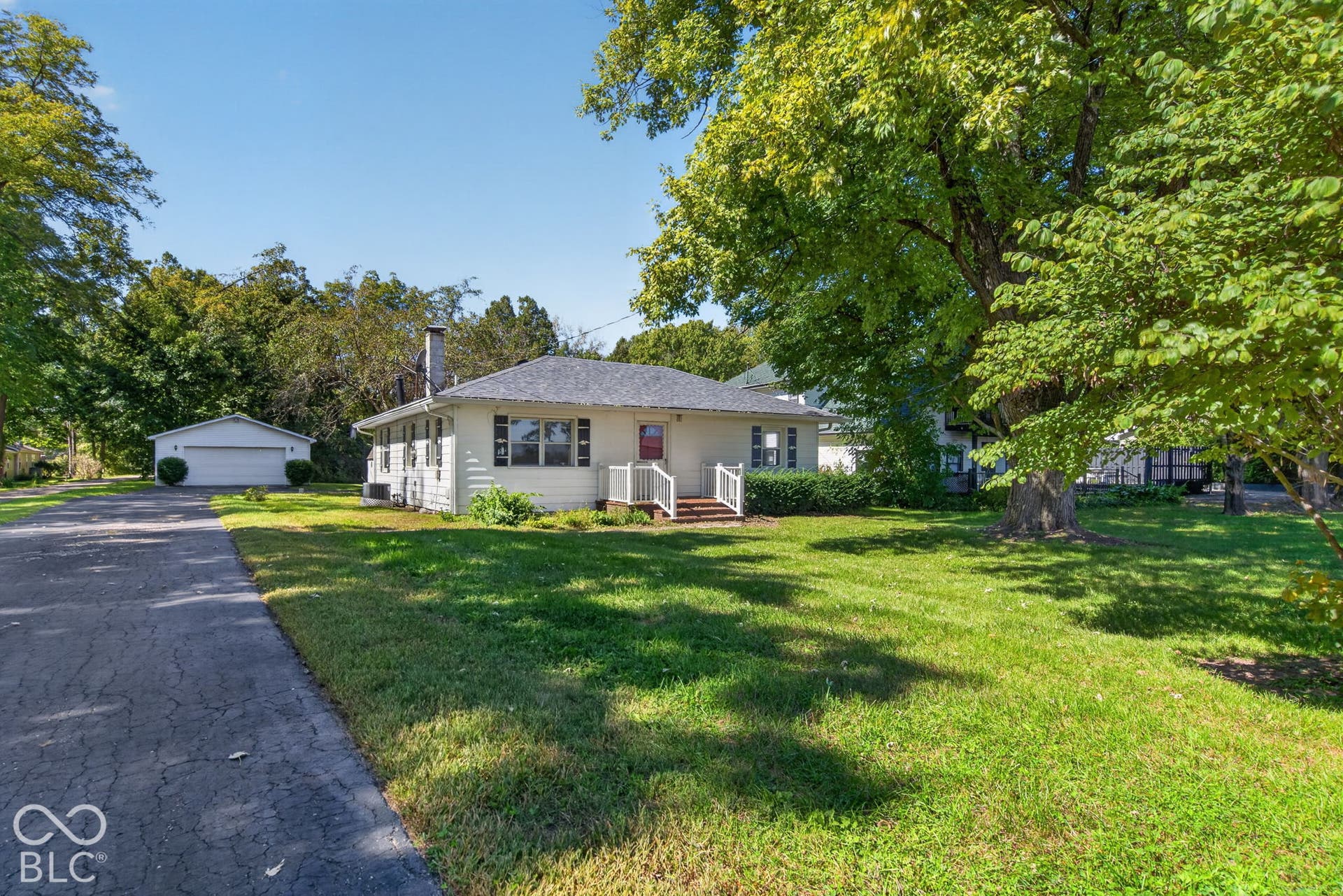 White exterior featuring a gabled roof and front porch with white railings