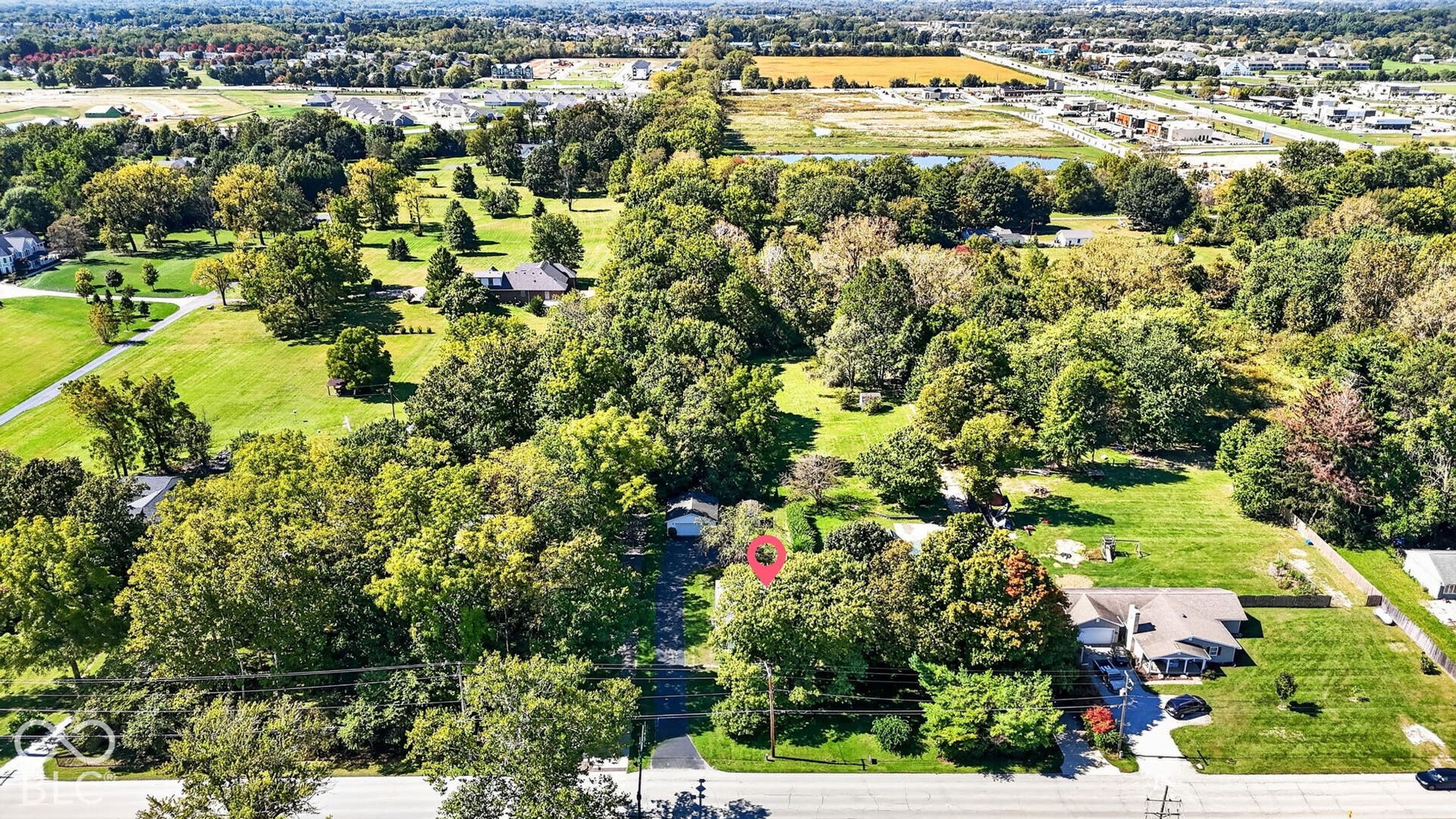 Expansive property with mature trees, green spaces, and a residential structure