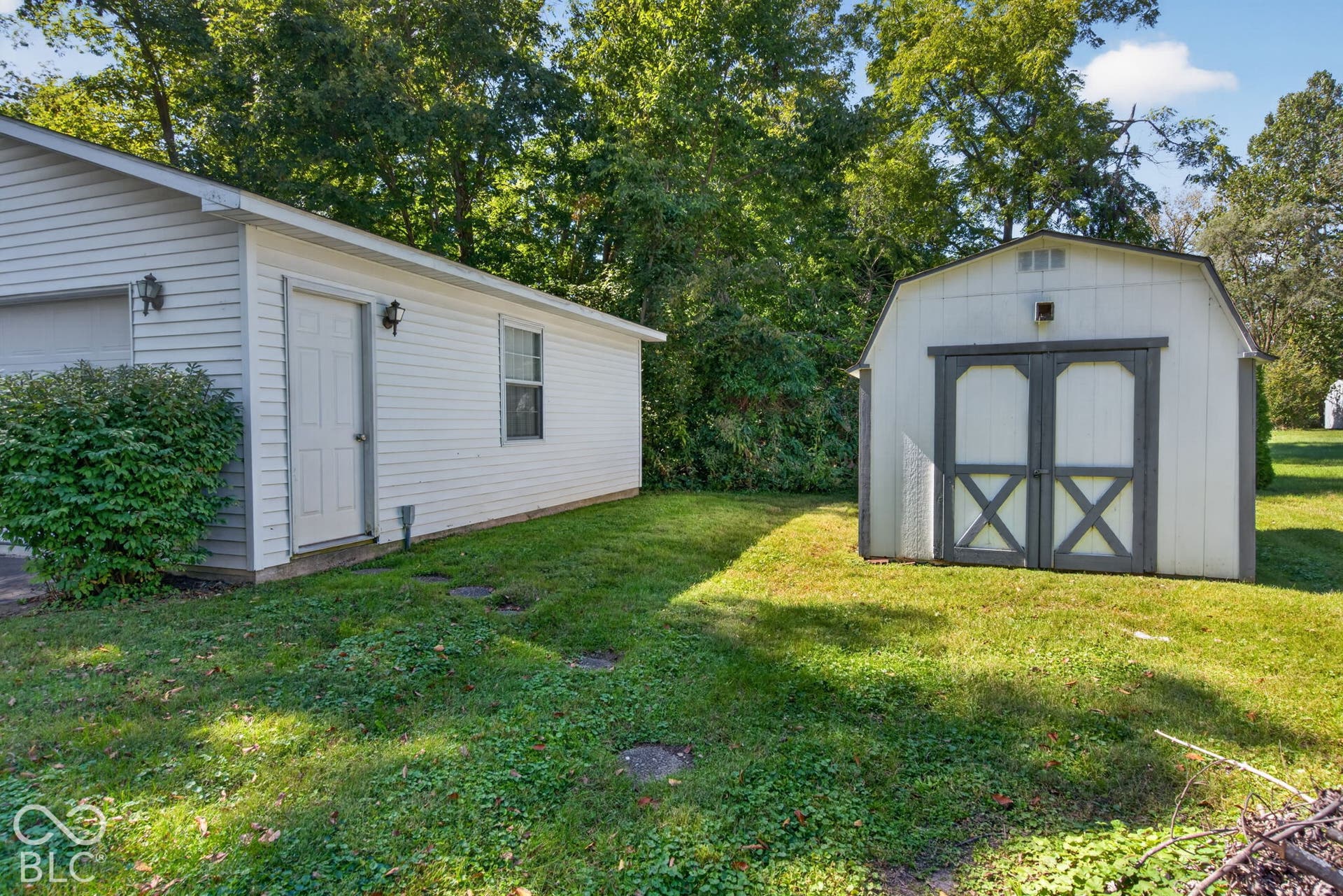 Detached garage with siding exterior and an additional storage shed