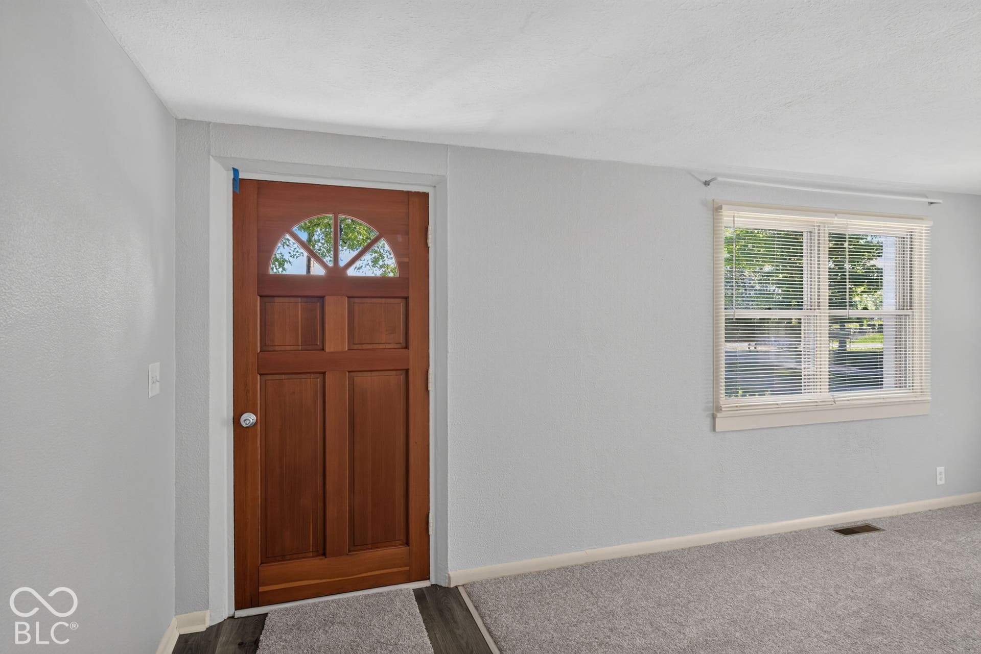 Wood-paneled entry door with an arched transom window