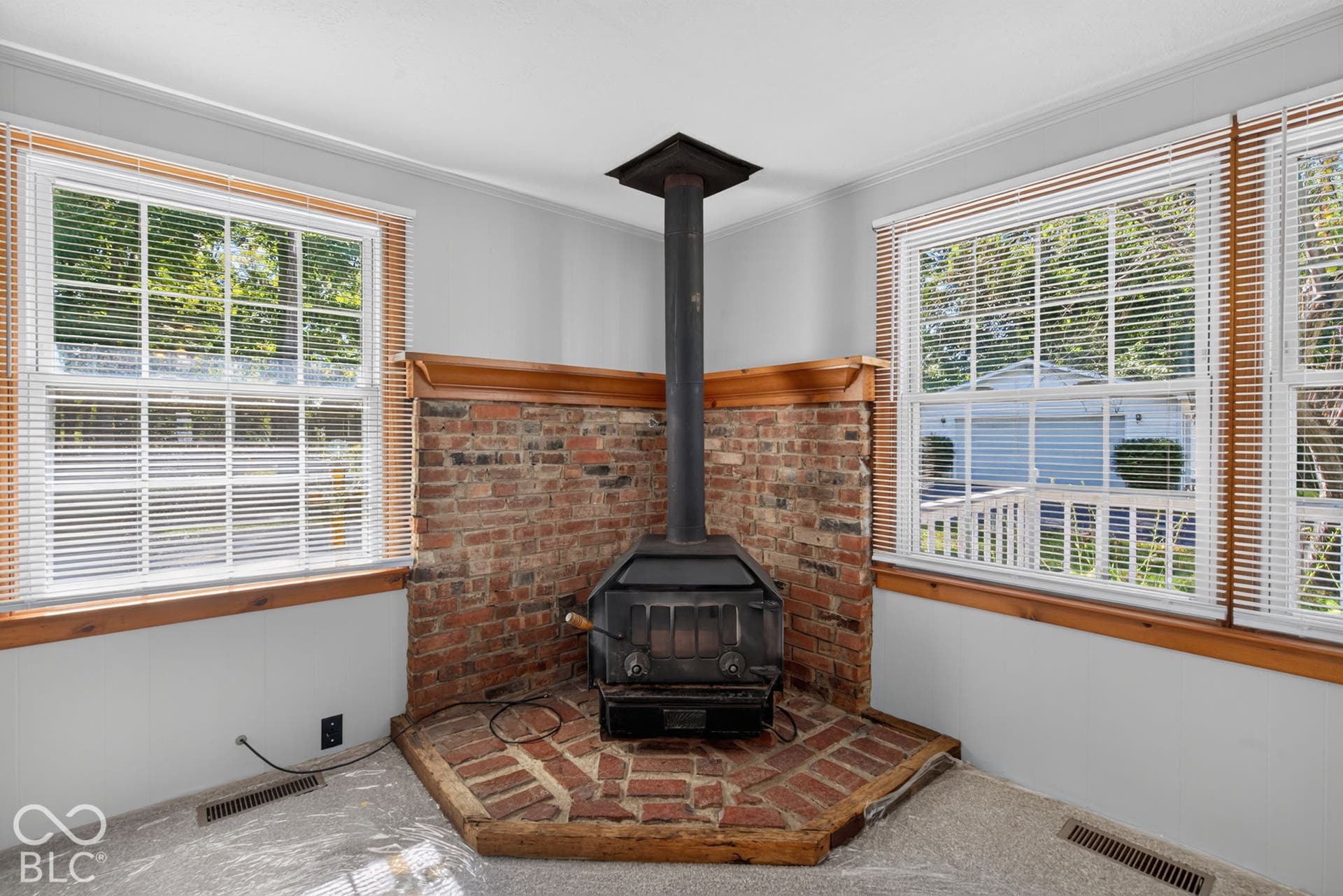 Corner wood-burning stove with a brick hearth and surround